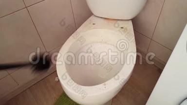 <strong>做家务</strong>的男服务员试图用液体清洁剂和刷子解开一个非常脏的厕所